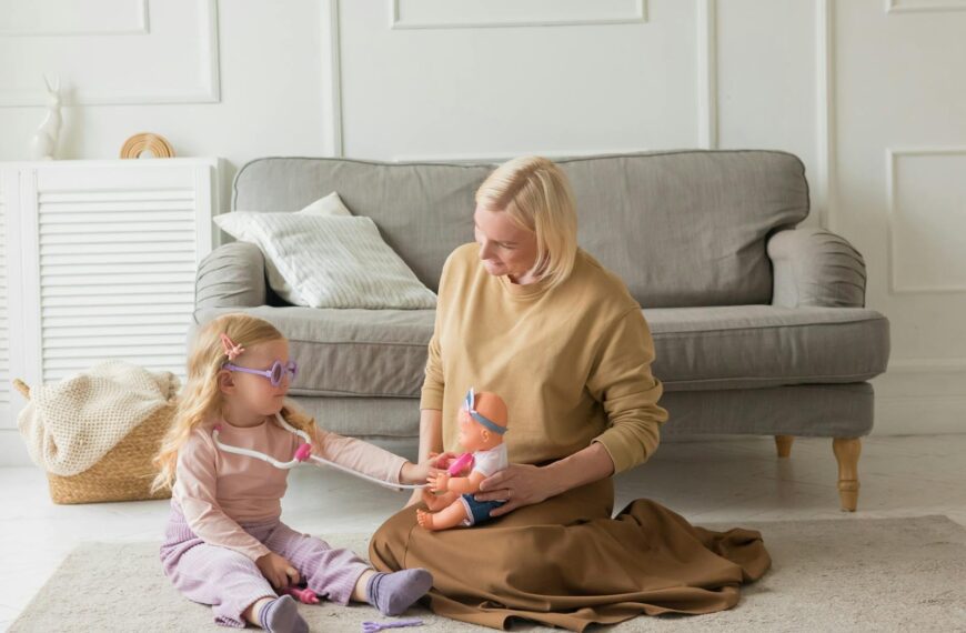 A mother and daughter enjoy quality time together, playing with a toy doll indoors.