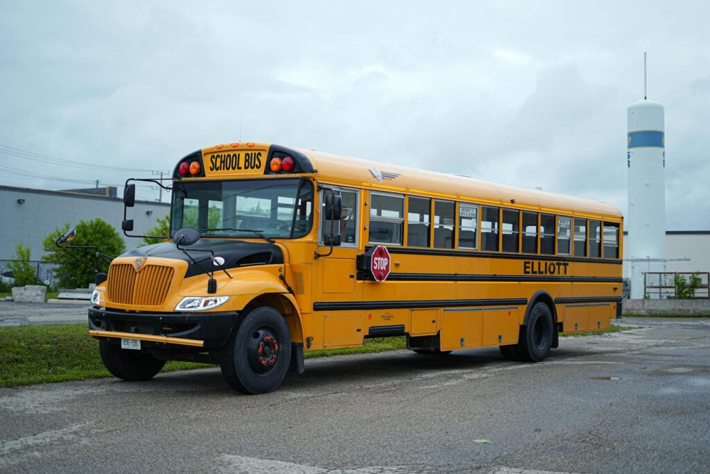 Yellow school bus parked in Kitchener, Ontario under a cloudy sky.
