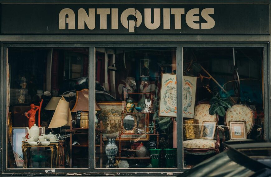 Explore a quaint Parisian antique shop with an elegant window display showcasing vintage treasures.
