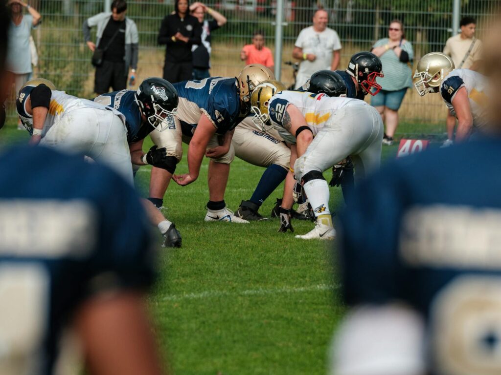 Dynamic shot of an American football game with players in action and cheering crowd in the background.