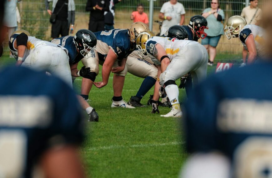 Dynamic shot of an American football game with players in action and cheering crowd in the background.