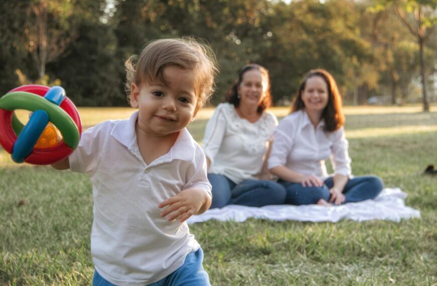 A joyful family enjoying a picnic in the park with a playful toddler in the foreground.