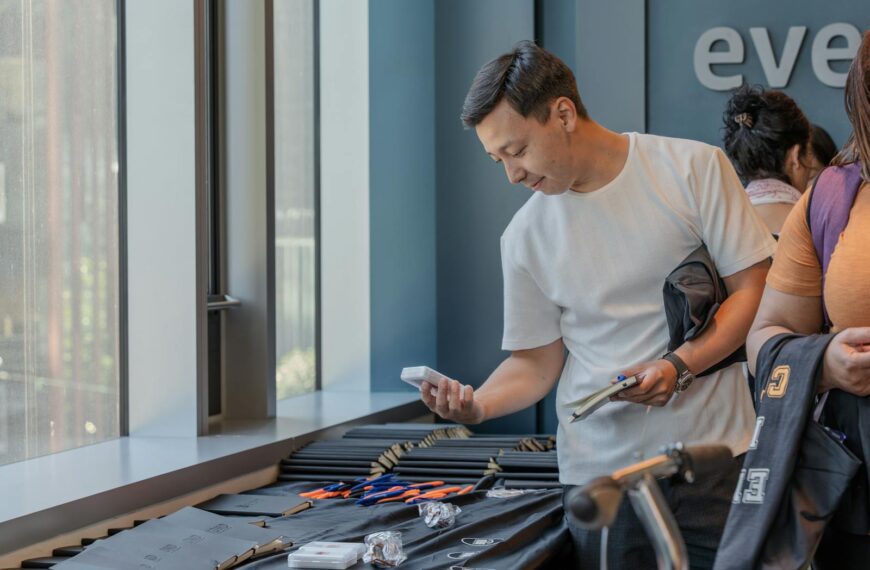 Adult man examines items at a table indoors during a community event, showcasing engagement.