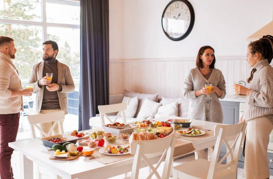 Friends enjoying a cozy brunch indoors with a full spread of delicious food and drinks.