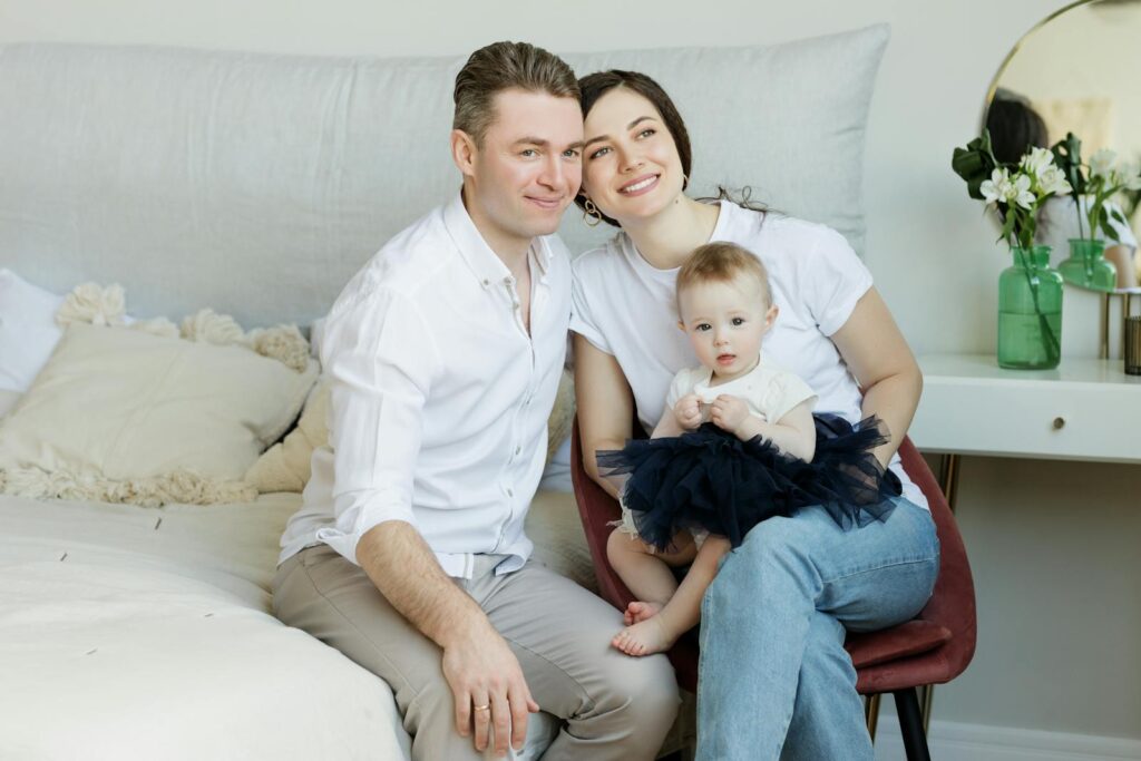 A joyful family moment with parents and their baby, captured in a cozy home environment.