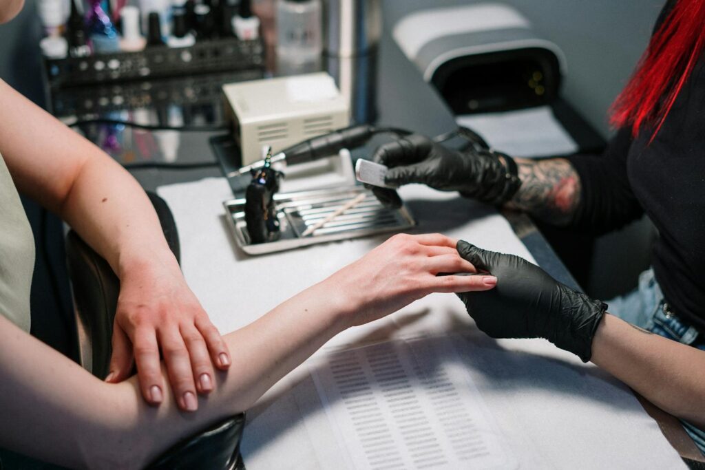 Close-up of a manicure process with black gloves and nail polish in a nail salon.