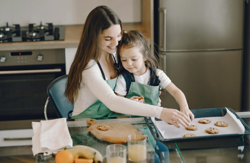 A mother and daughter bonding while baking cookies in a cozy kitchen setting.