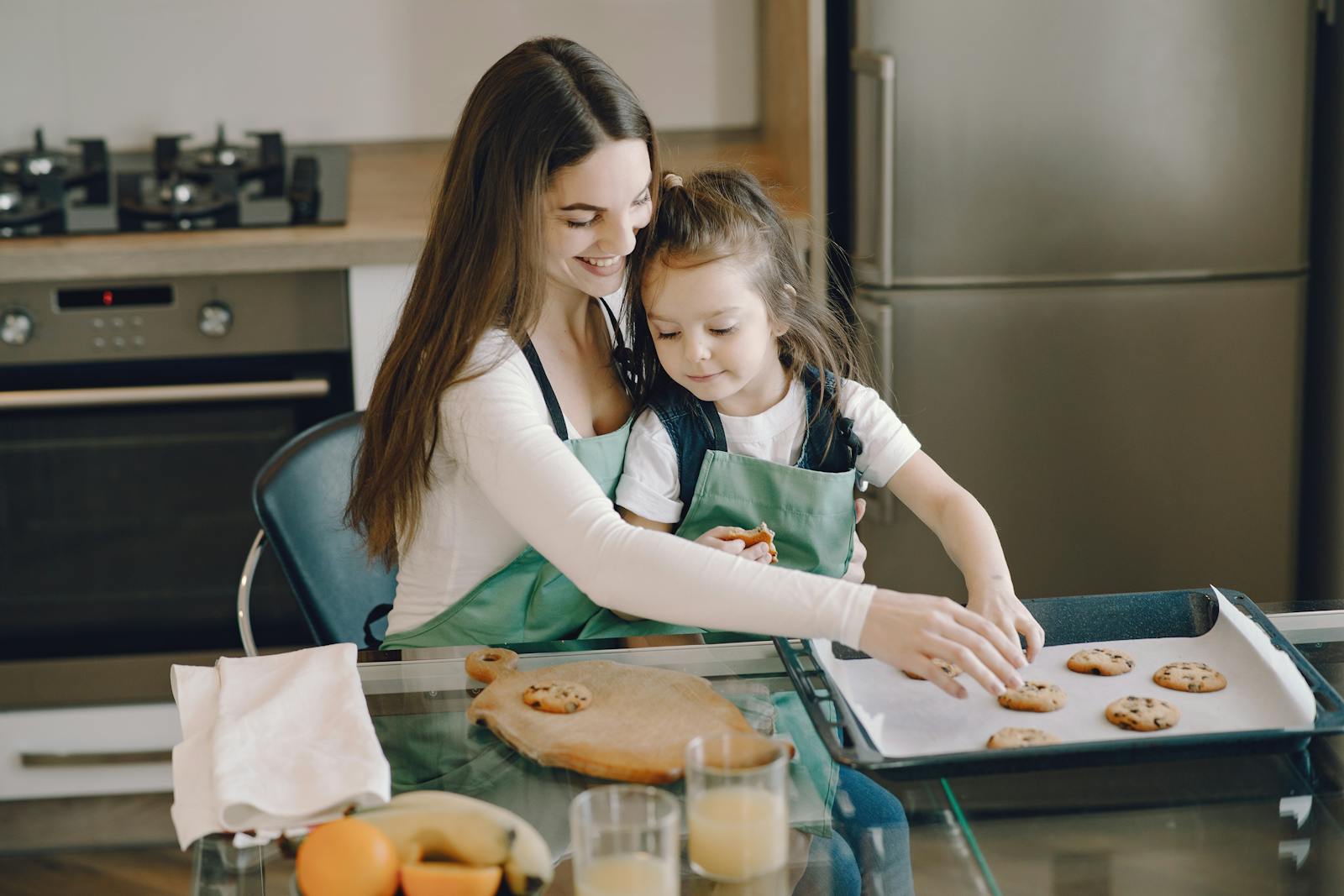 A mother and daughter bonding while baking cookies in a cozy kitchen setting.