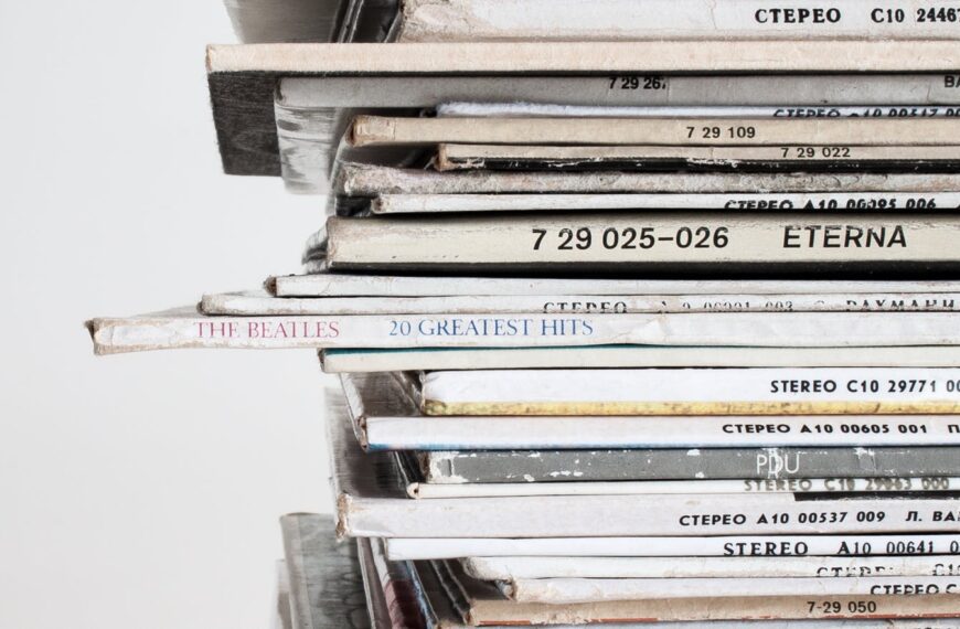 Close-up shot of a stacked pile of vintage vinyl record albums showcasing classic music covers.