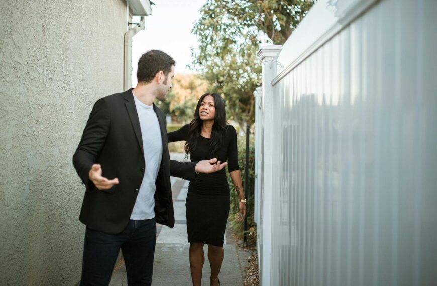 A couple arguing in an outdoor narrow passageway, showcasing relationship tension.