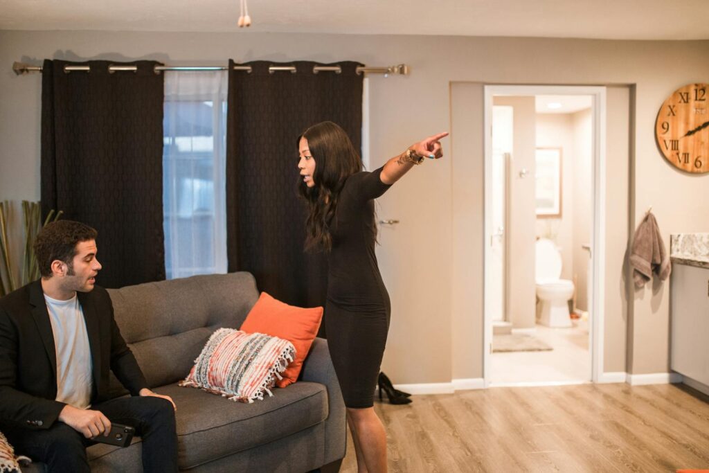 A tense moment as a couple argues in a stylish living room, indicating emotional conflict.