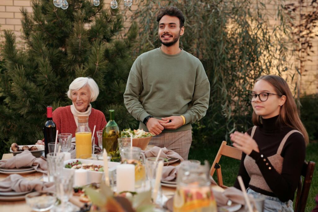 A diverse family enjoying a meal together outdoors, showcasing warmth and togetherness.