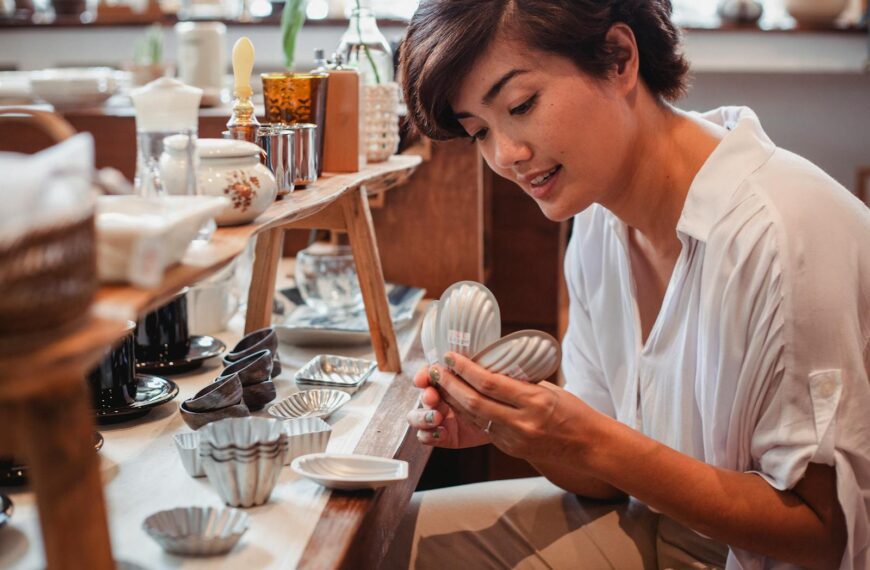 A young Asian woman shopping for decorative kitchenware in a store.