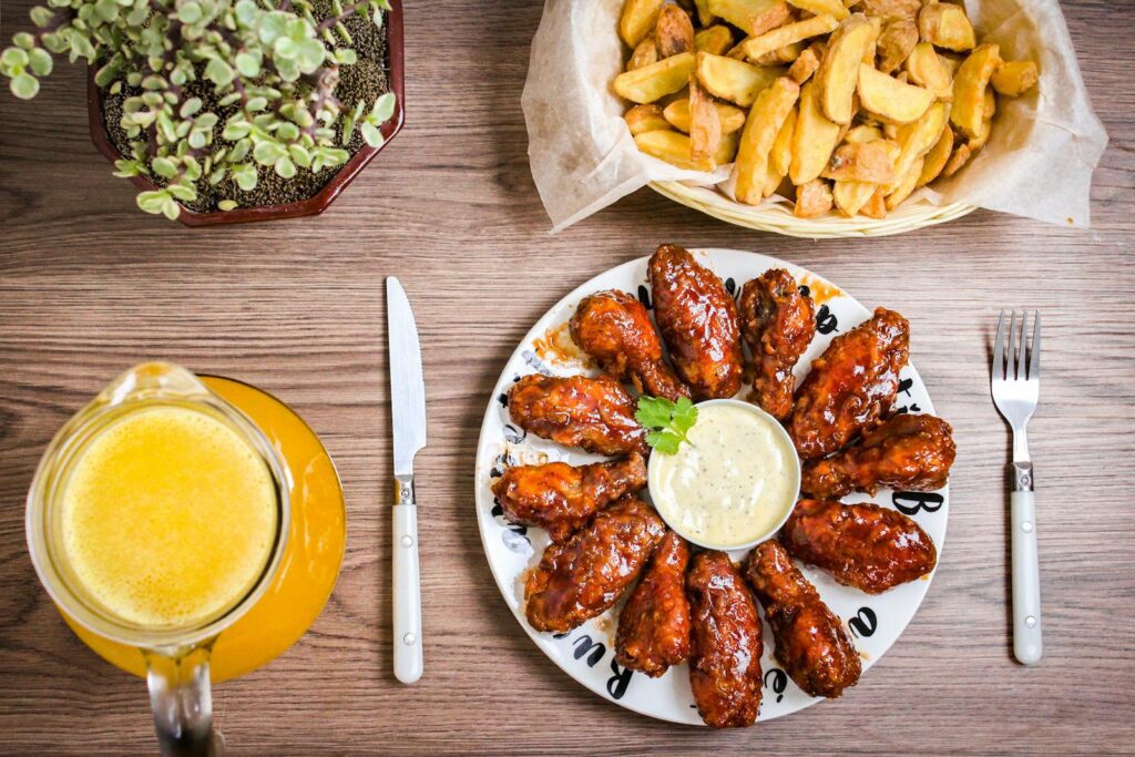 Mouthwatering glazed chicken wings paired with crisp fries and a refreshing beverage. Perfect for a tasty meal.