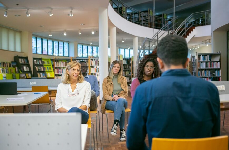 Group of attentive diverse classmates and teacher listening carefully presentation of student at seminar in university class