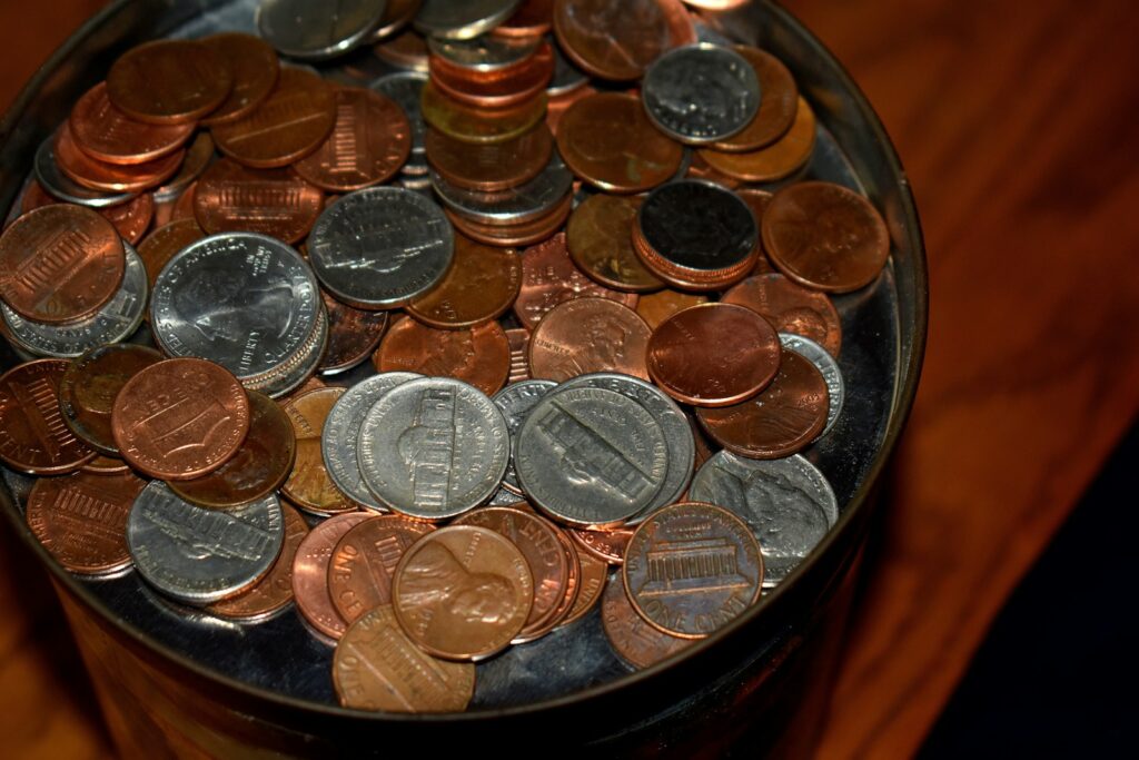 A close-up of a jar filled with pennies and nickels.