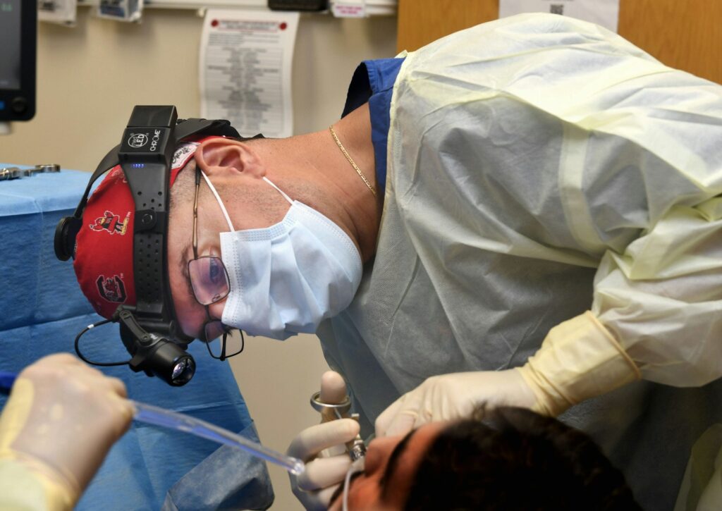 Surgeon performing a medical procedure with instruments.