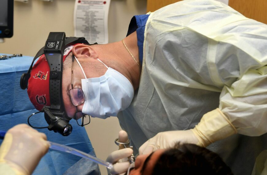 Surgeon performing a medical procedure with instruments.