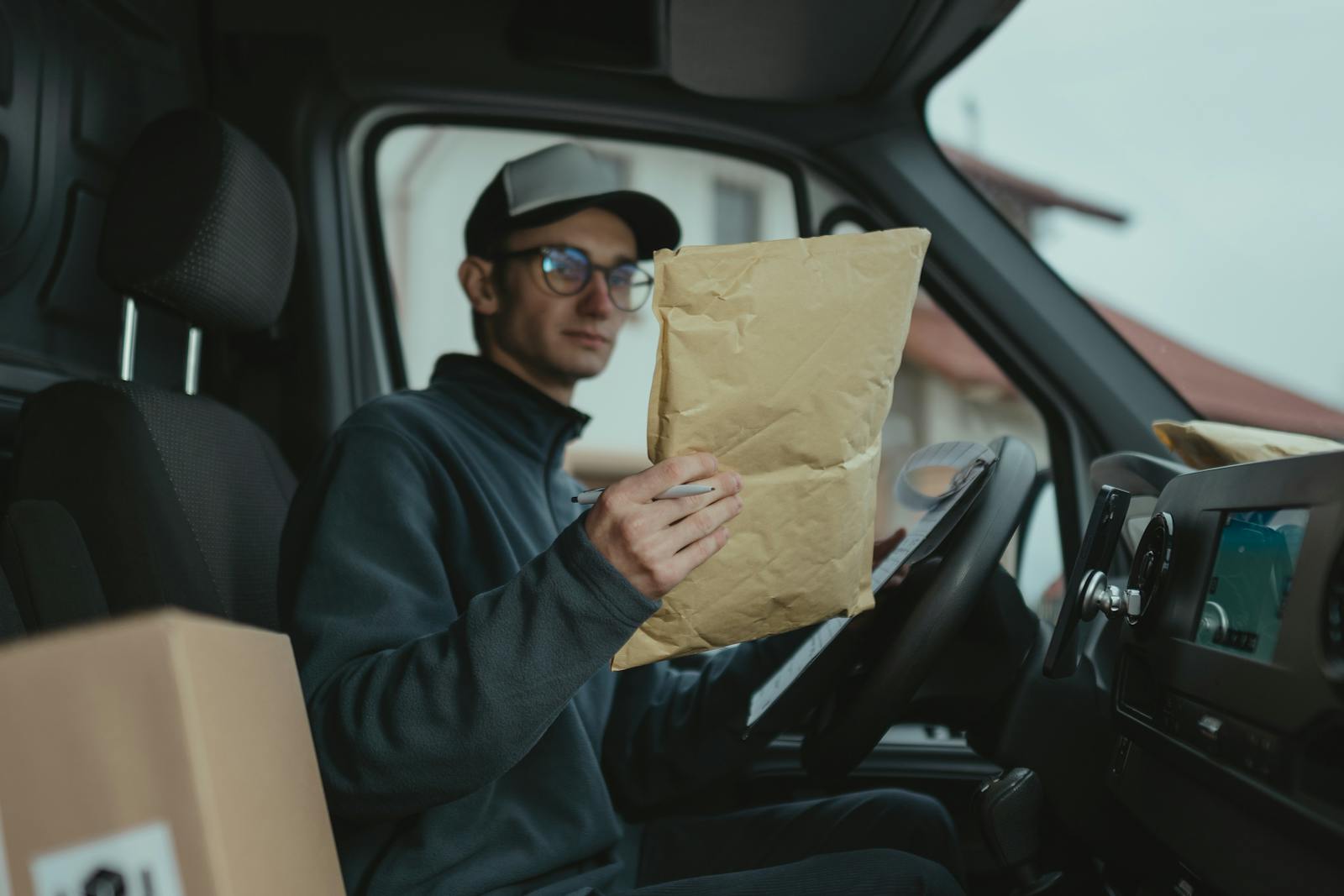 Delivery worker examining packages inside a van, focused on logistics.