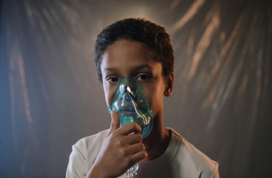Portrait of a child using an oxygen mask indoors, highlighting health care needs.