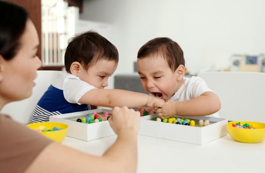Two young boys playfully interacting with wooden beads at home.