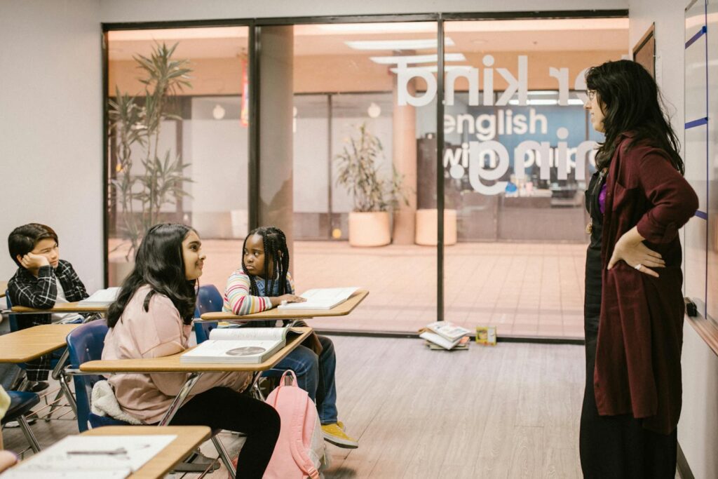 A teacher engages with students in a modern classroom setting promoting education and interaction.