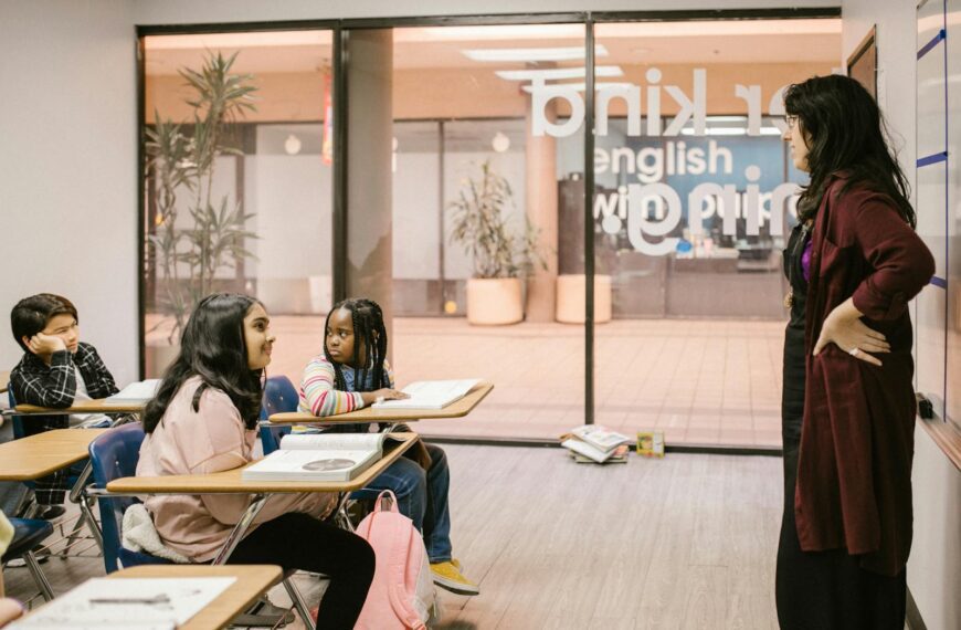 A teacher engages with students in a modern classroom setting promoting education and interaction.
