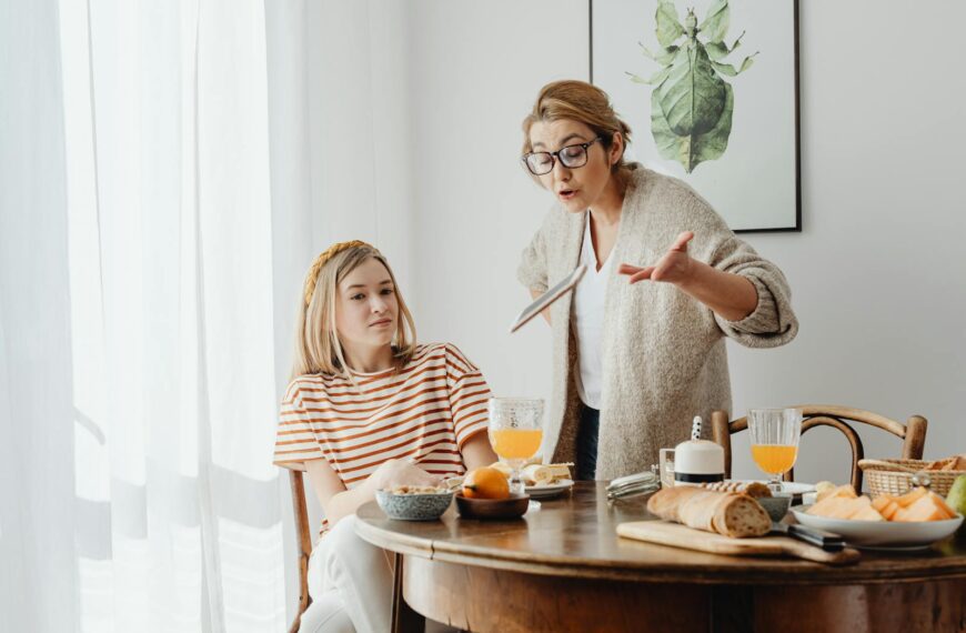 A mother and teenage daughter having a tense breakfast conversation at home.