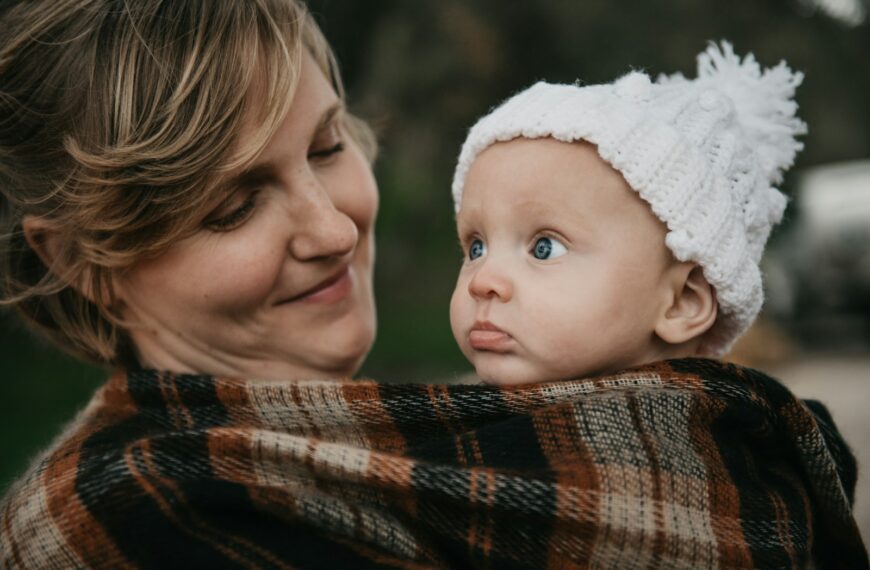 a woman holding a baby wrapped in a blanket