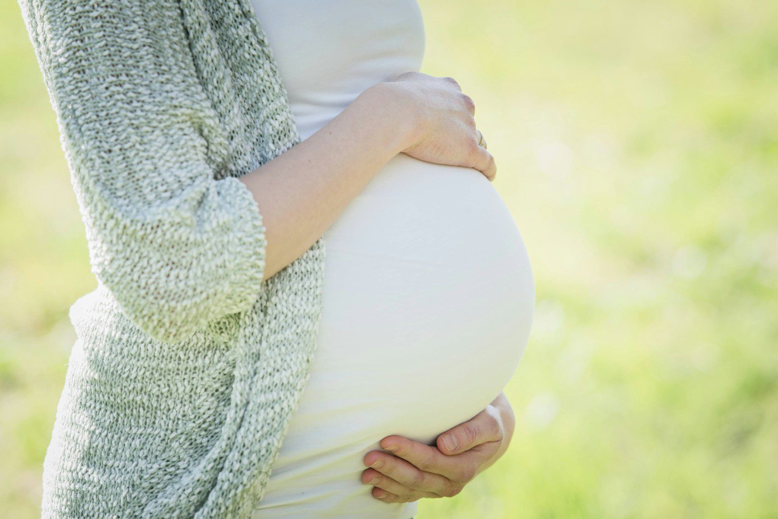 a pregnant woman holding her belly in her hands