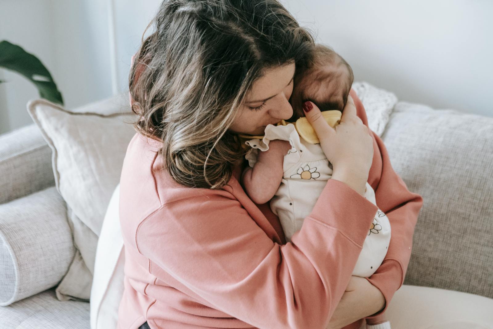A mother lovingly embraces her baby at home, creating a warm and cozy atmosphere.