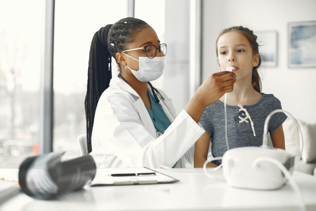 A healthcare professional examines a young girl with a medical device in a clinical setting.