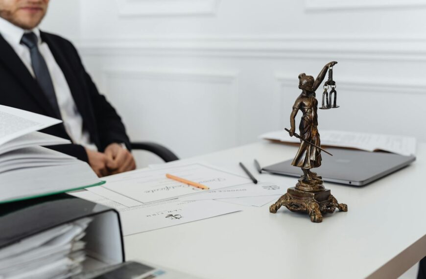 A legal professional's workspace featuring Lady Justice statue, documents, and a laptop.