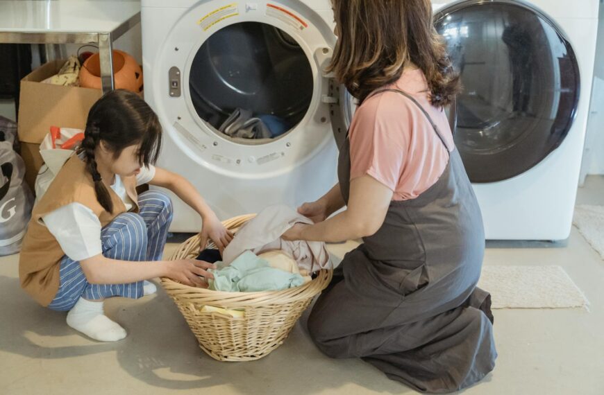 A mother and daughter sorting laundry together in a cozy home setting.