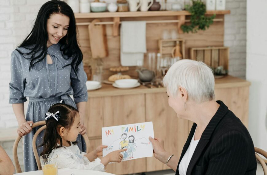 A family sharing a joyful moment as a child presents a drawing, emphasizing love and connection.