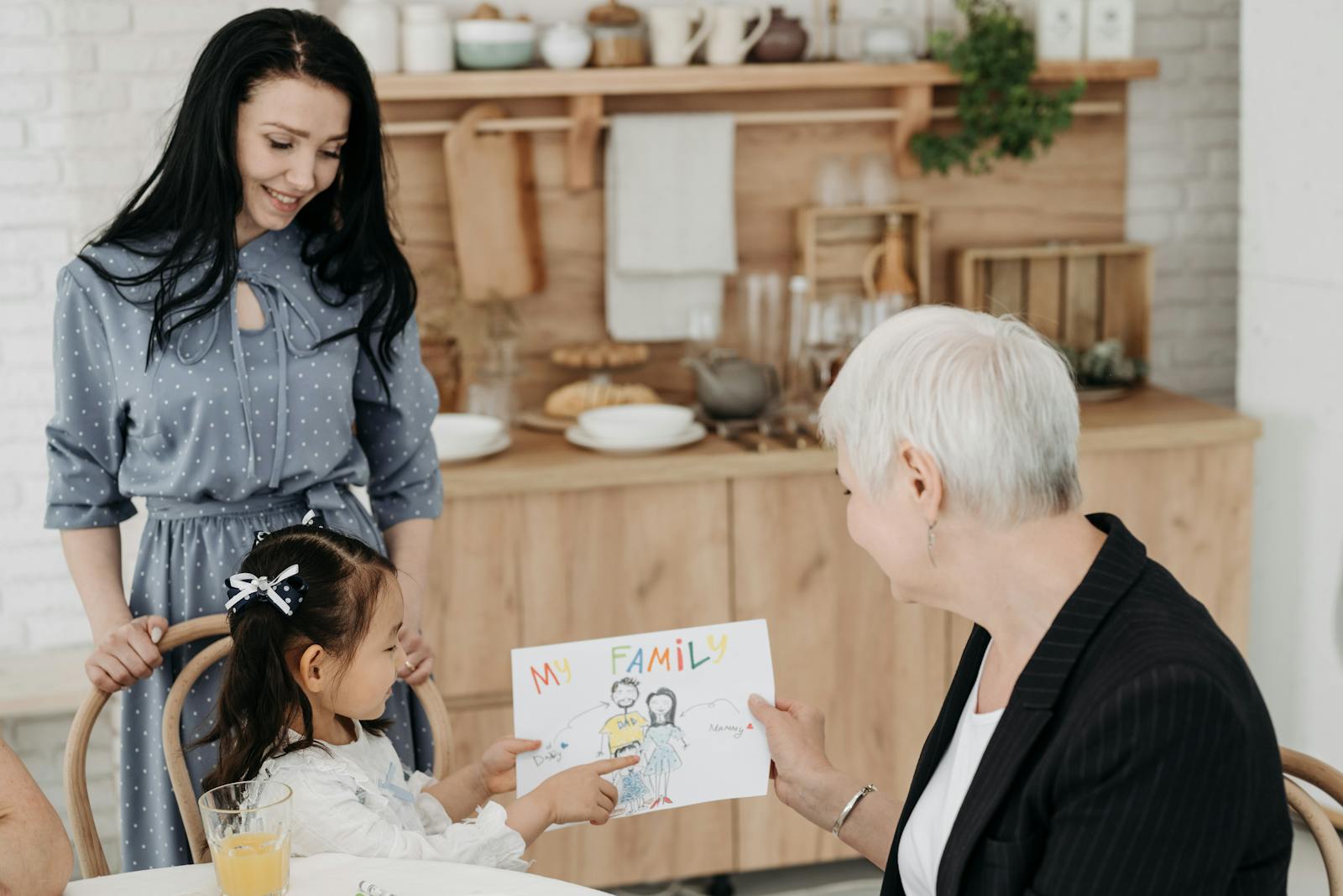 A family sharing a joyful moment as a child presents a drawing, emphasizing love and connection.