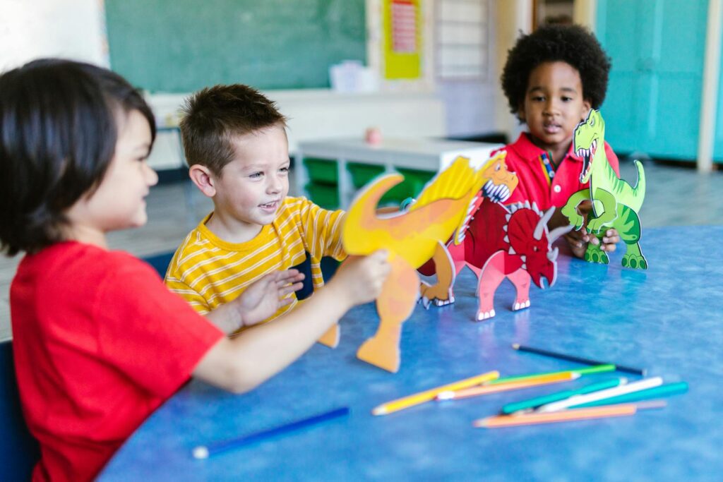 Three kids playing with dinosaur figures, fostering imagination and learning.