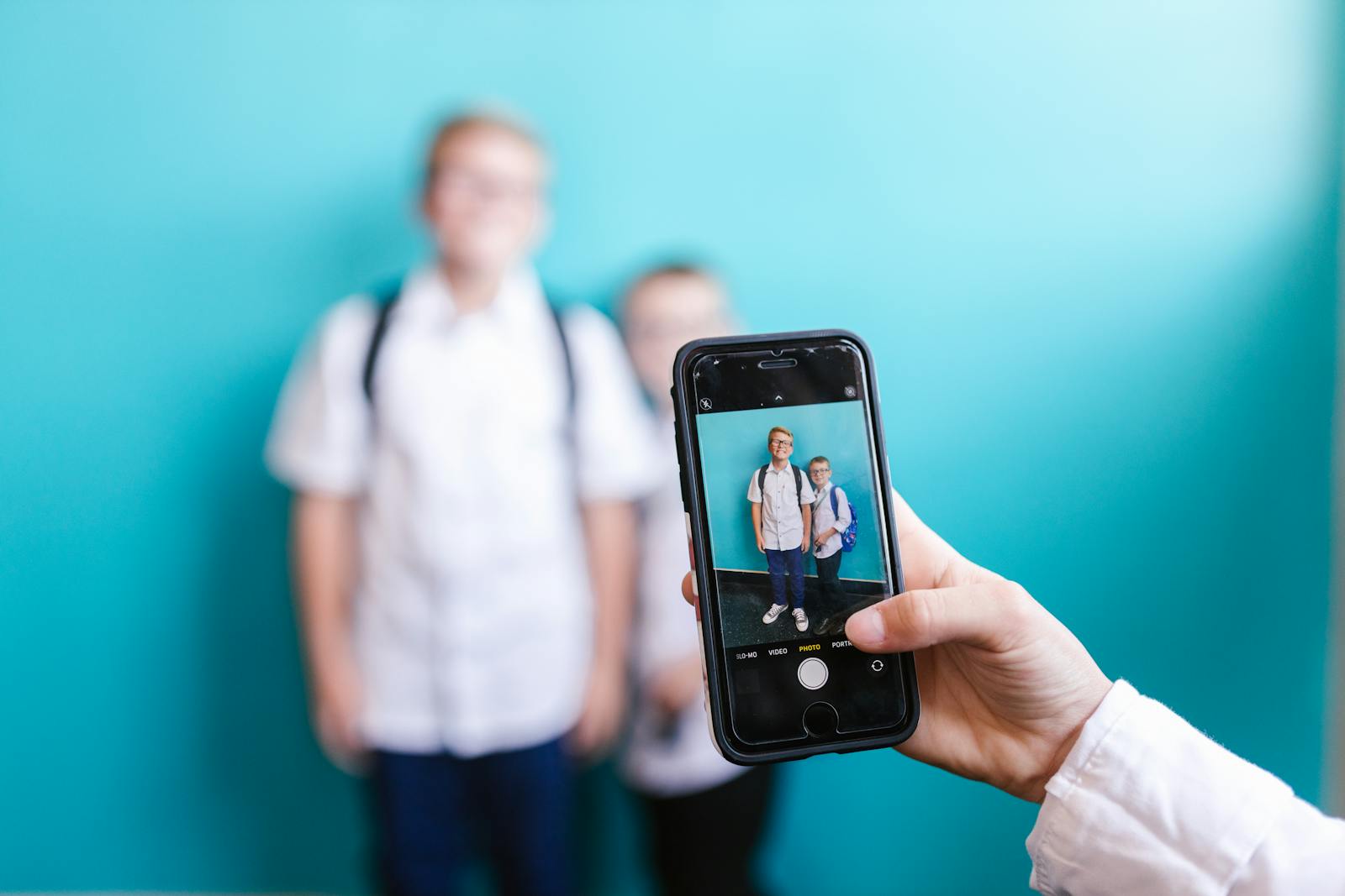 A close-up shot of a smartphone capturing two boys against a vibrant background.