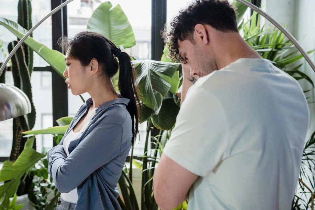 A couple argues in a lush indoor garden, creating a tense atmosphere.
