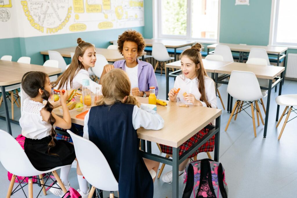 A diverse group of school children enjoying lunch together in a canteen.