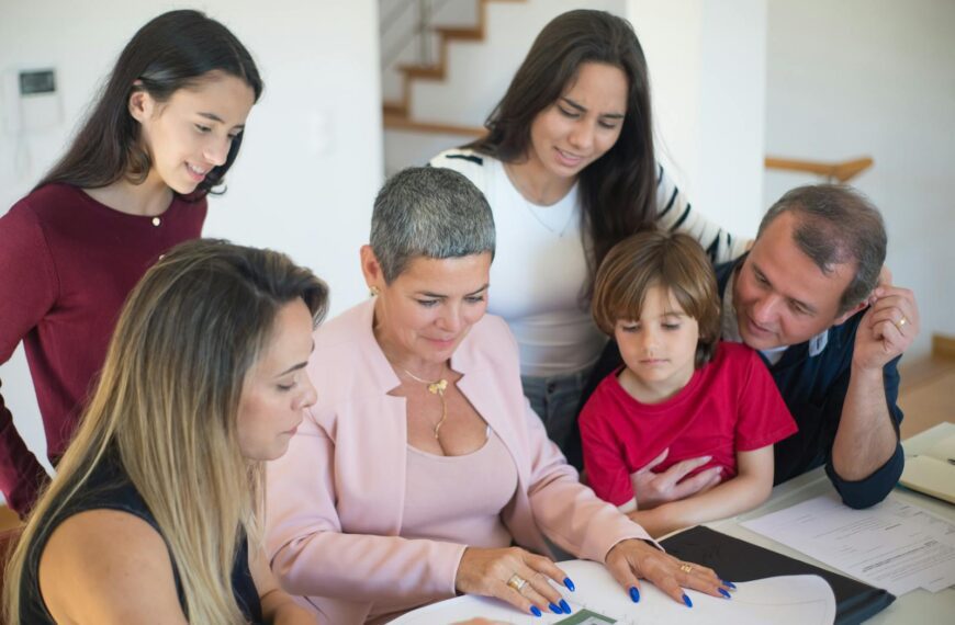 A family discusses real estate documents at home with a realtor, fostering communication and planning.