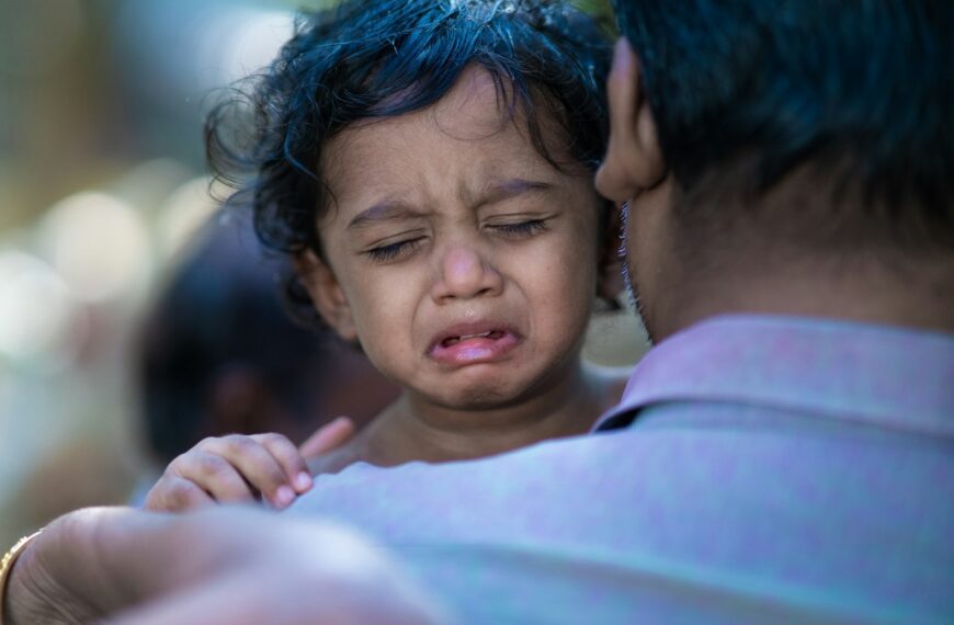 a woman holding a child with a surprised look on her face