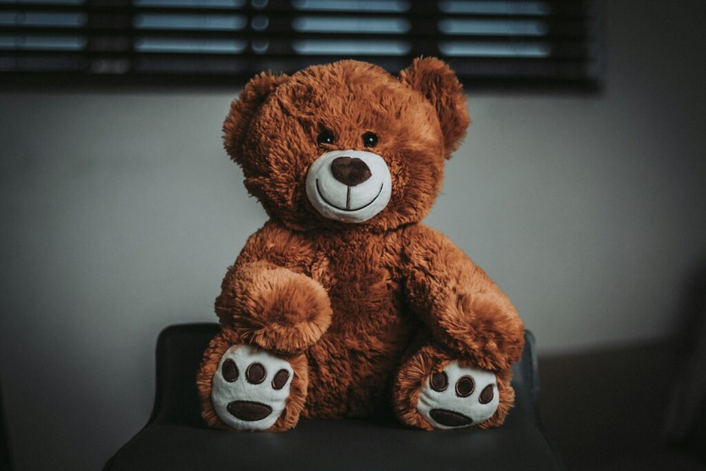 a brown teddy bear sitting on top of a black chair