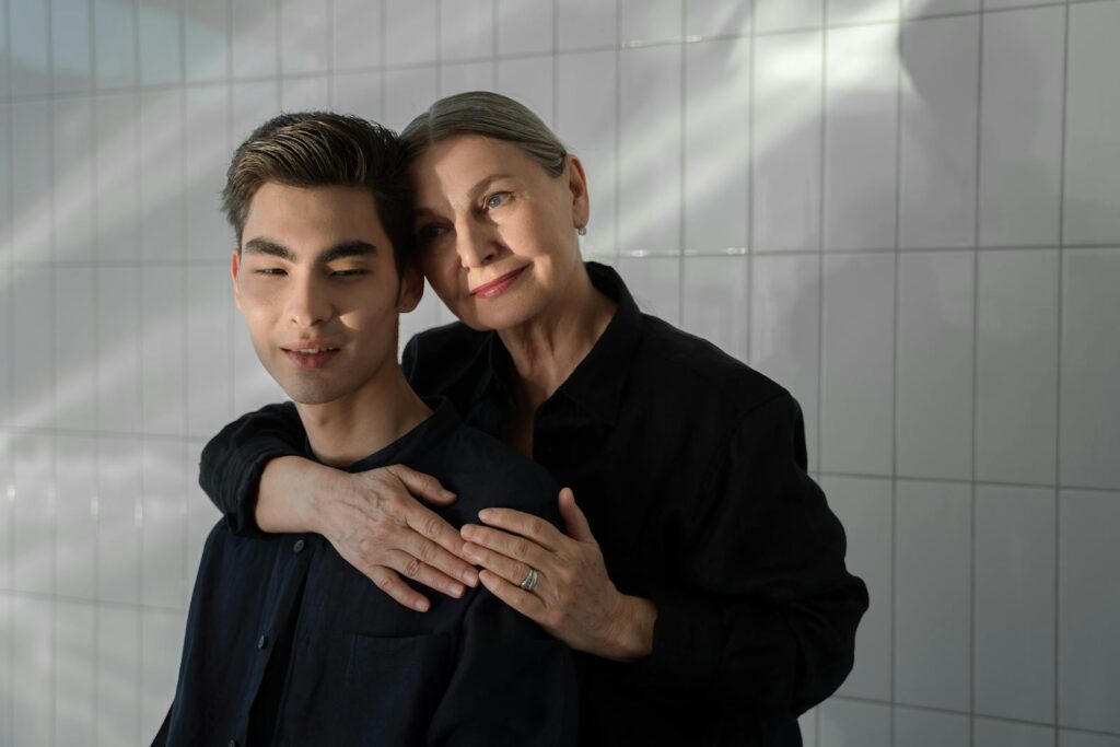 A heartfelt embrace between a mother and her son captured in a warm indoor setting.