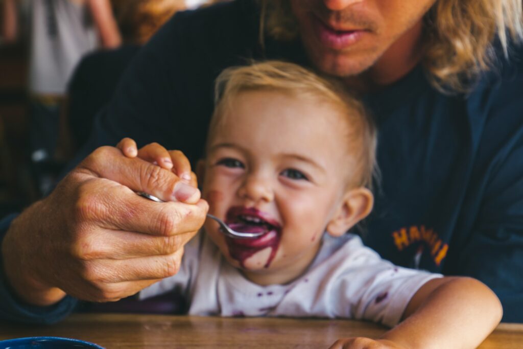 a woman feeding a child a spoon of food