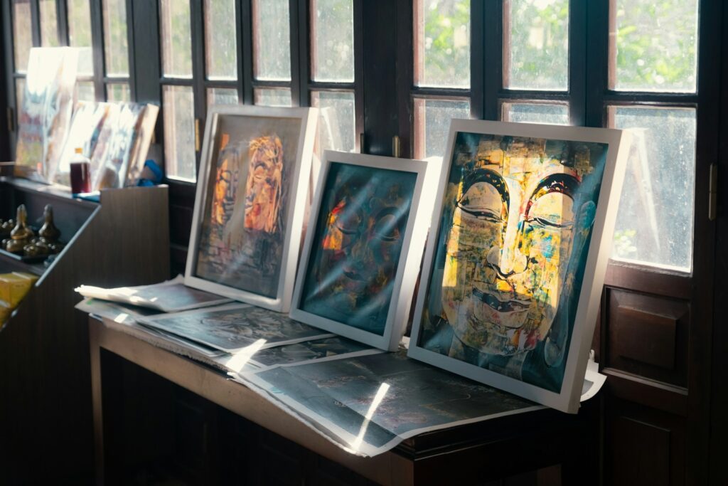 Art is displayed on a table near windows.