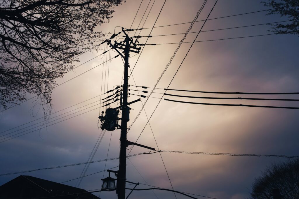 Telephone pole with wires against dramatic cloudy sky