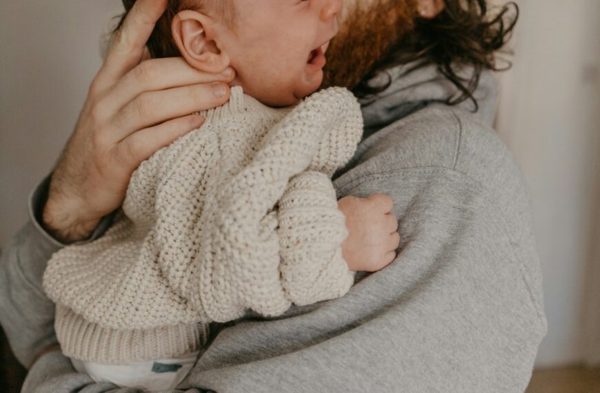 a man holding a baby in his arms