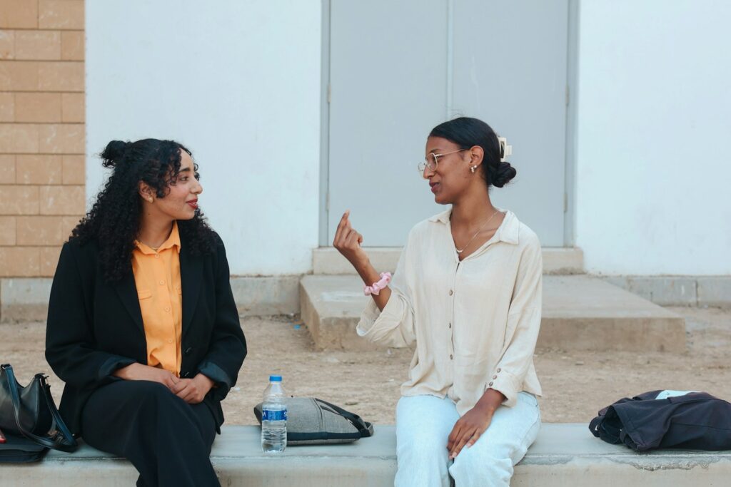 Two women talking while sitting outdoors