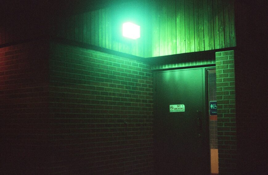 a green light shines on the side of a building